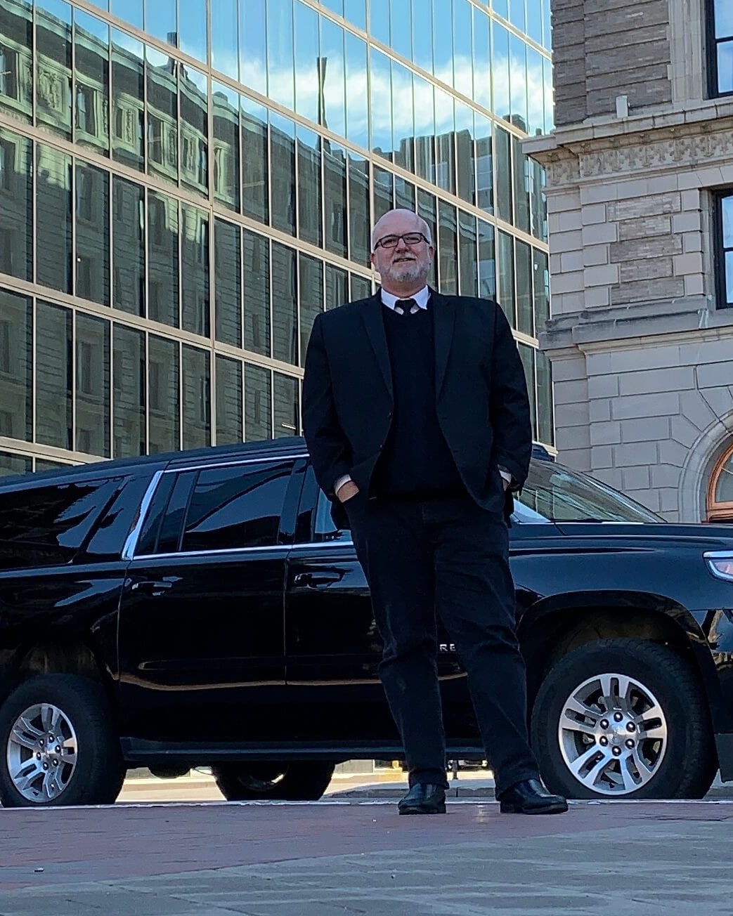 Black car chauffeur with SUV near Flynn Cruiseport Boston for private cruise transportation and passenger pickup.