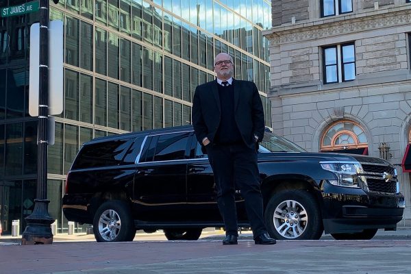 Professional Boston Preferred Car Service chauffeur with luxury SUV in Boston